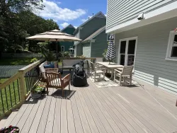 Spacious composite backyard deck with black metal railing and outdoor dining area, built by a trusted deck contractor near me in Charlotte, NC