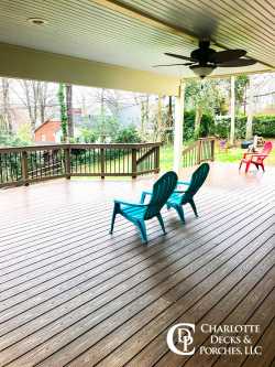 Covered composite deck with ceiling fan and black railing overlooking backyard, built by a trusted deck contractor near me in Charlotte, NC