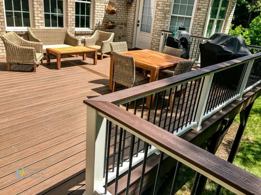 Spacious composite deck with light wood tones and white railings, featuring wide steps and plenty of room for outdoor furniture.