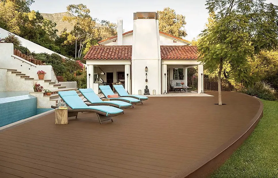 Side view of a raised deck with wooden steps and railings, showcasing a spacious outdoor area elevated from the ground for an enhanced backyard experience.