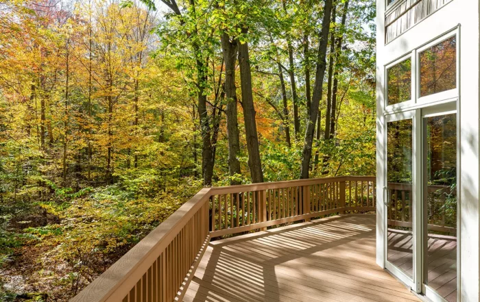 View from the deck of a luxury home in the autumn woods. Outdoor living concept with bright fall foliage.