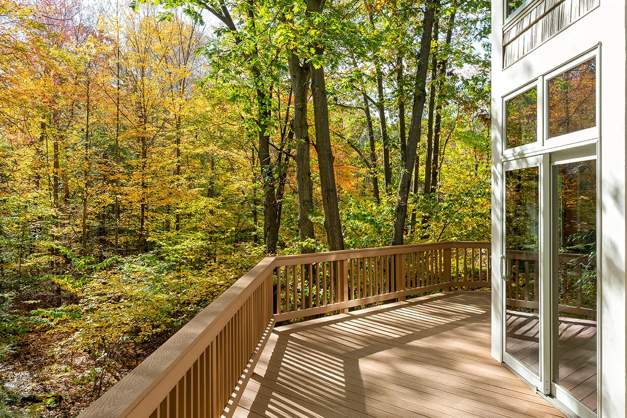 View from the deck of a luxury home in the autumn woods. Outdoor living concept with bright fall foliage.